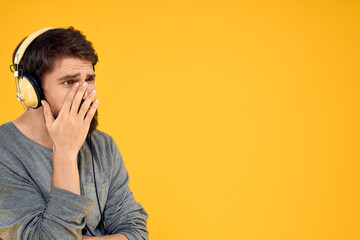 Man in headphones listens to music technology lifestyle fun people yellow background