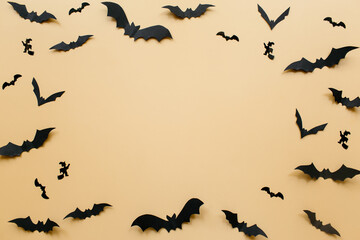 Halloween decorations with bats on pastel beige background. Halloween concept. Flat lay, top view, copy space