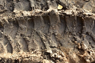 Footprint of wheel tread on the ground road. The trail from the tread of trucks wheels. Car tire tread imprint on sand, background, texture. Footprints rubber tyres from automobile