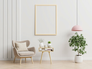Poster mockup with vertical frames on empty white wall in living room interior with blue velvet armchair.
