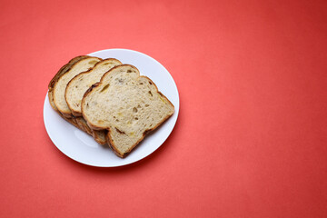 Slices of bread in a plate on red background 