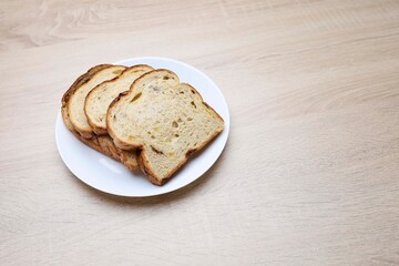 Slices of bread in a plate on wooden table 