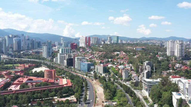Espectacular vista a&eacute;rea panor&aacute;mica del skyline de Santa Fe con el drone volando sobre la autopista a Toluca con un cielo azul como fondo