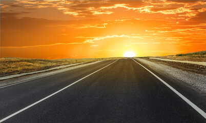 Empty suburban highway at sunset illuminated by the sun