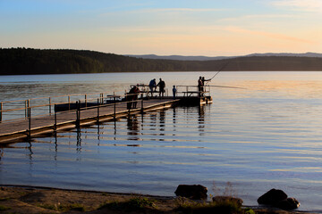 fishermen fish with rods at sunset