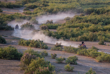 ATVs ride on a dirt road