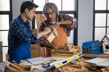 Young and senoir carpenters working and training on wood craft handmade using professional tools  at workshop to produce construction material or wooden furniture . DIY maker and carpentry