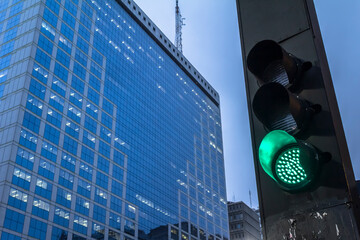 green semaphore on Paulista Avenue with office buildings background in Sao Paulo city