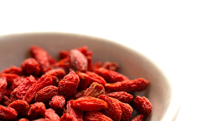 白バックと左側に白いお皿とクコの実　右側にコピースペース