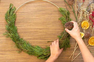 Cute woman decorates advent wreath with her hands