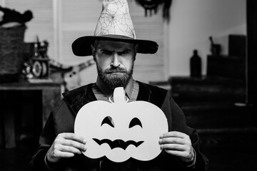 Man with a pumpkin. Halloween. Black and white photo with a handsome man on Halloween.