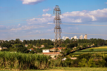 Power transmission tower in countryside with the urban area in the background