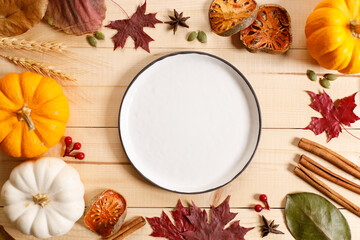 Autumn background with empty dish and dried leaves on dark wooden table