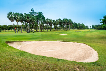 Beautiful view landscape in morning time green grass at golf course ,big trees, sand bunker and mist with sunlight rays background