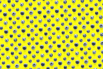 Background of Freshly picked blueberries on yellow backdrop.