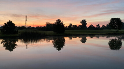 Naklejka na ściany i meble sunrise golf course colorful sky fairway pond reflections