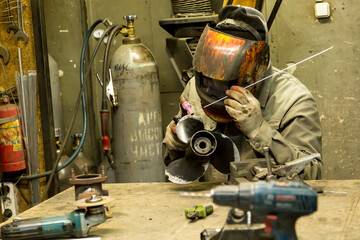 Welder solders copper car radiator with gas torch