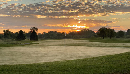 Naklejka na ściany i meble colorful sunrise golf course green white flag foggy fairway