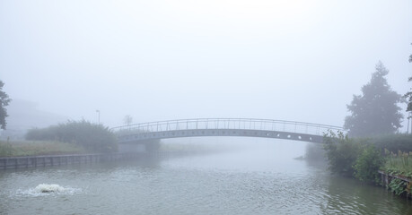 foot bridge over the water with fog