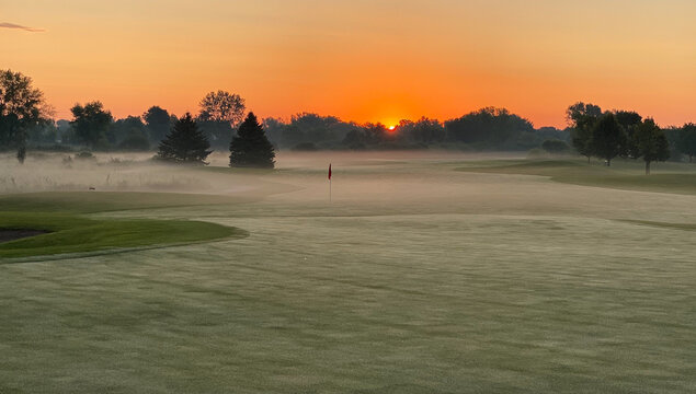 Orange Sunrise Golf Course Foggy Fairway Green Red Flag