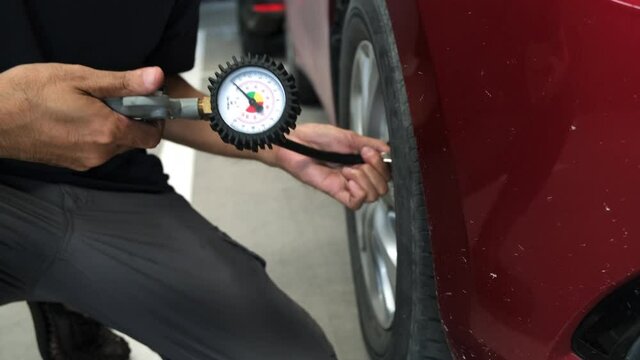 Man inspection Measure quantity Inflated Rubber tires car Close up hand holding machine Inflated pressure gauge for car tyre pressure measurement for automotive automobile 4K video