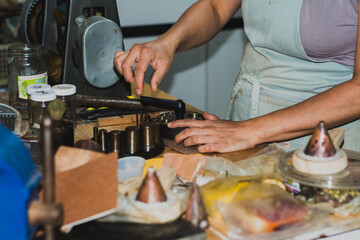 Jewelry maker woman working in professional jewelry workshop at her workbench.