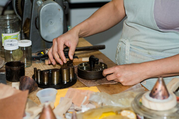 Jewelry maker woman working in professional jewelry workshop at her workbench.