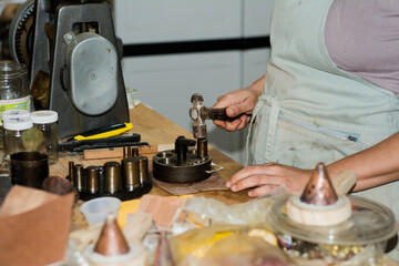 Jewelry maker woman working in professional jewelry workshop at her workbench.