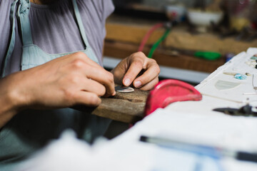 Jewelry maker working in the professional jewelry workshop at his workbench.