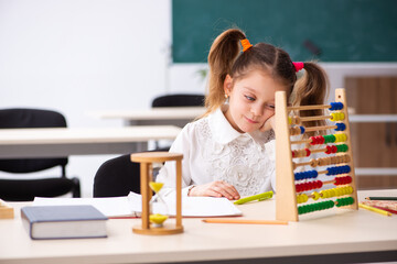 Small girl with abacus in the classroom