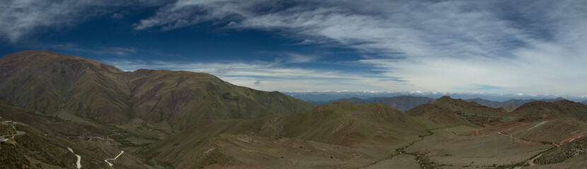 Panorama view of the popular landmark Bishop's slope in Salta, Argentina. The green valley, field, mountains and road under a beautiful blue sky with clouds. 