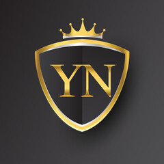 Initial logo letter YN with shield and crown Icon golden color isolated on black background, logotype design for company identity. - obrazy, fototapety, plakaty