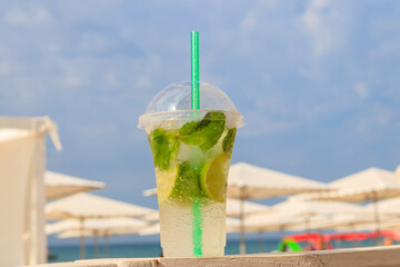 Fresh mojito cocktail on a table on a background of tropical beach