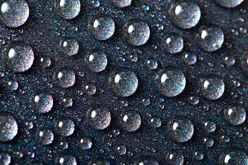 Gray texture with water drops in close-up, round droplets on a dark abstract background