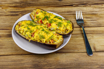Baked stuffed eggplants on a wooden table. Healthy food and dieting concept