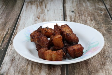 Deep fried cutting pork belly or streaky pork on the plate. Famous roasted or grilled marinated pork with soy sauce and pepper in Asia restaurant. 