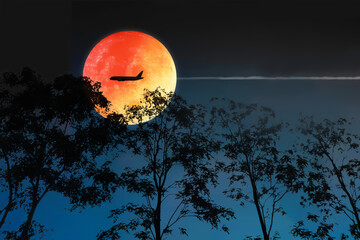 Dramatic atmosphere and lovely romantic beautiful super moon night sky clouds and stars with silhouette aircraft and trees.