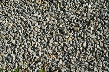 Closeup of road texture with small pebbles that are in variations of a grey color.