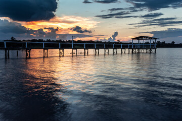 Fototapeta premium pier on the edge of a lake with sunset background in Brazil