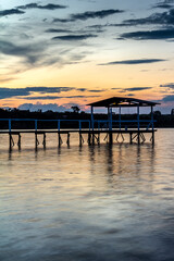 Fototapeta na wymiar pier on the edge of a lake with sunset background in Brazil