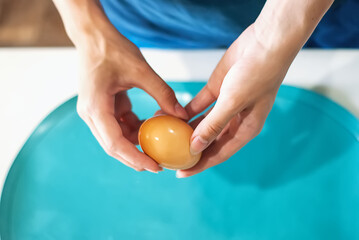 The hands of an unrecognizable woman peel a boiled egg. The process of cleaning eggs. Woman preparing Breakfast.  Photo of beautiful elegant female hands that clean an egg. Keto diet. Health food.