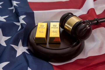 gold bars with justice law hammer lying on usa flag