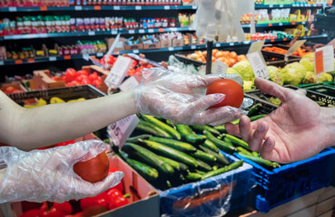 buyer in gloves chooses vegetables during a pandemic due to a new dangerous virus, coronavirus