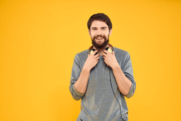 Man with headphones listening to music lifestyle technology studio yellow background