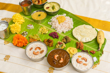 Traditional Onam sadhya, boiled rice, served for Kerala Indian festival  with curries Sambar, Rasam, Pulisseri, Avial, Thoran, Papadum, Payasam, Banana, Yogurt or Buttermilk, chips