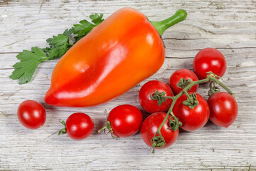 Freshly picked cherry tomatoes, bell pepper on old wooden surface