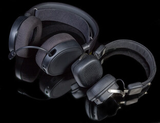 Fototapeta na wymiar Headset and headphones with different earpads types on dark surface