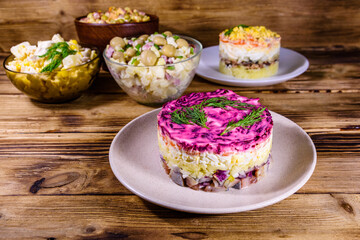 Set of festive mayonnaise salads on wooden table