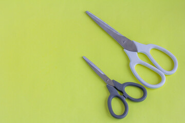 Scissors, big scissors and small scissors on a yellow background. White and black scissors with a copy of the space.