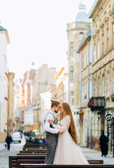 Exquisite newlyweds standing facing each other against the backdrop of morning city